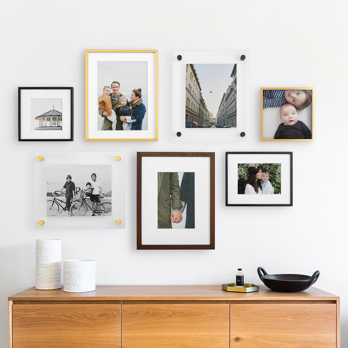 wall decor different frames on a white wall over a wooden piece of furniture