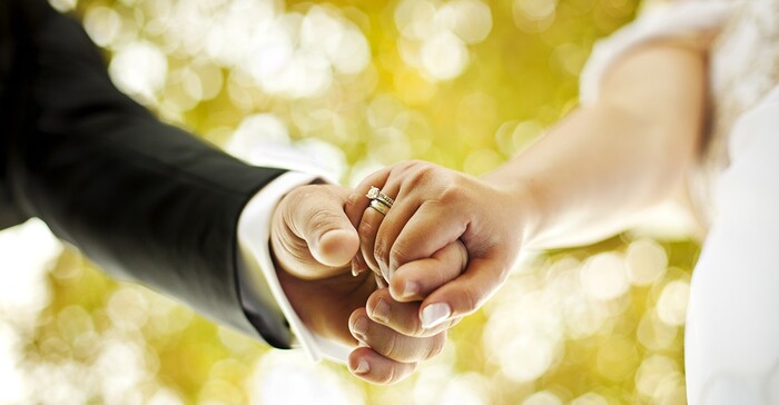 wedding picture man in a black suit holding bride's hand 