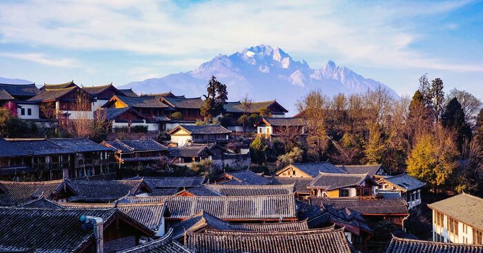 yunan province china gray rooftops of village houses with a rocky mountain in the background