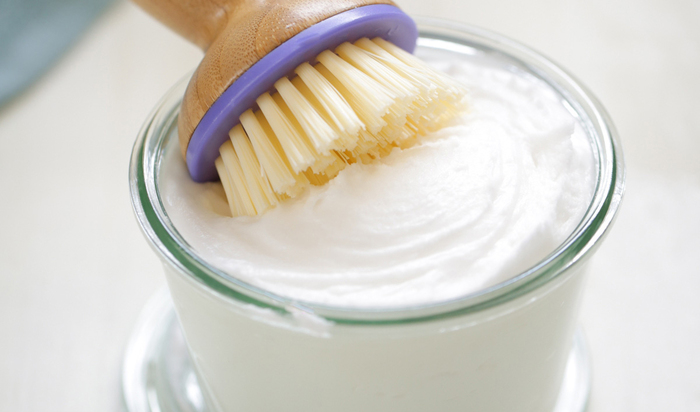 DIY soft cream cleaner in a glass jar with a wooden brush in it