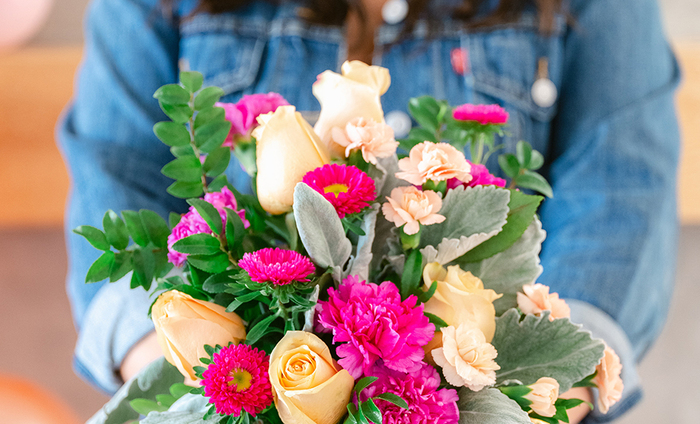 friendhsip flowers woman in jeans jacket holding a flower bouquet