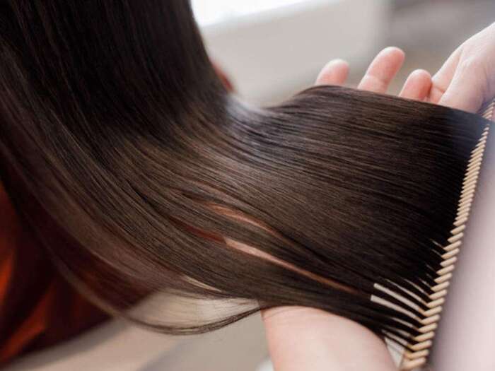 hair protection tips combing through a long dark hair