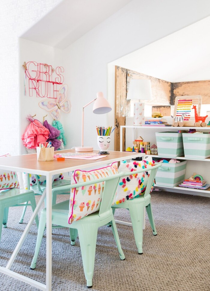 kitchen interior spring themed in pastel blue and pink with colorful decorative pillows on the chairs