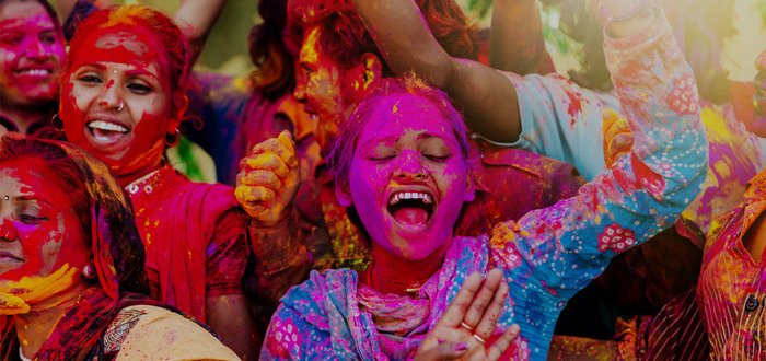 holi festival people of india singing and covered in colorful dyes