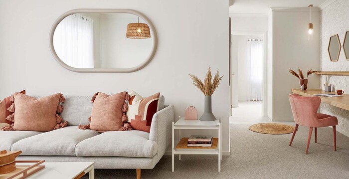 Living room in beige and pastel pink with light accents large mirror and white walls
