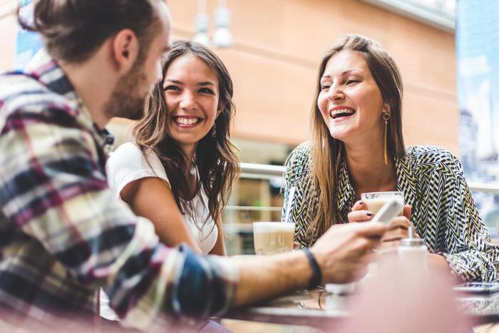 friends speaking laughing and having fun outdoors at a caffee