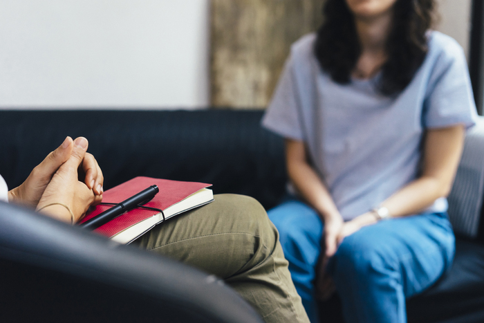 woman sitting on a couch across a therapist