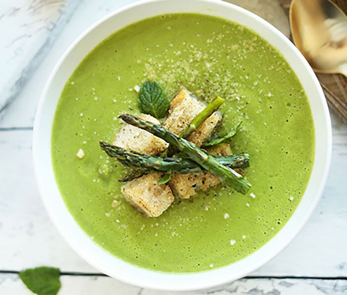asparagus cream soup green soup with asparagus croutons in a large white bowl on a wooden table surface