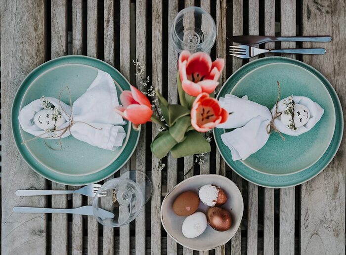 cute table decor for easter wooden table with green plates and red tulips painted eggs