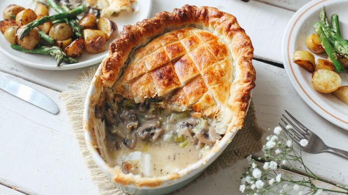 delicious recipes for Easter vegan mushroom pie on a white table surface with plates around