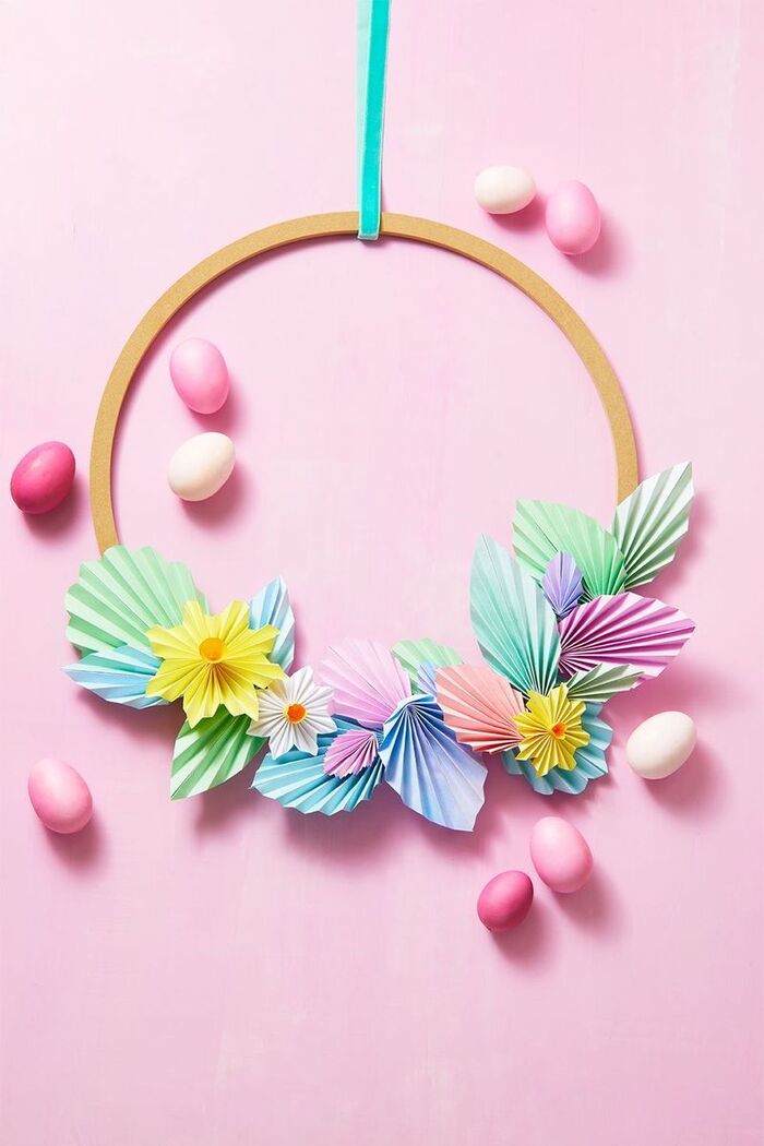 paper wreath on a pink background pink eggs and paper cut origami flowers