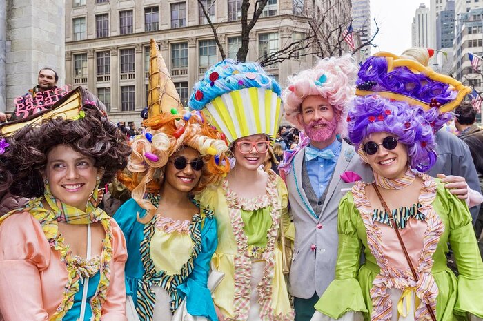 people in fancy fun carnival costumes outdoors celebrating easter parade in a city setting
