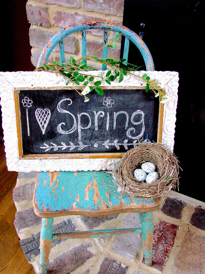 spring easter decor upcycled metal chair with a blackboard with Spring written on it and a little nest with eggs