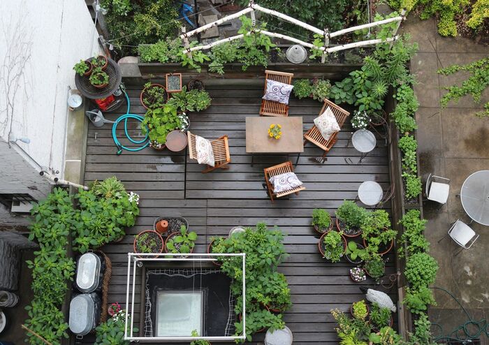 city garden from above with wooden furniture and potted plants
