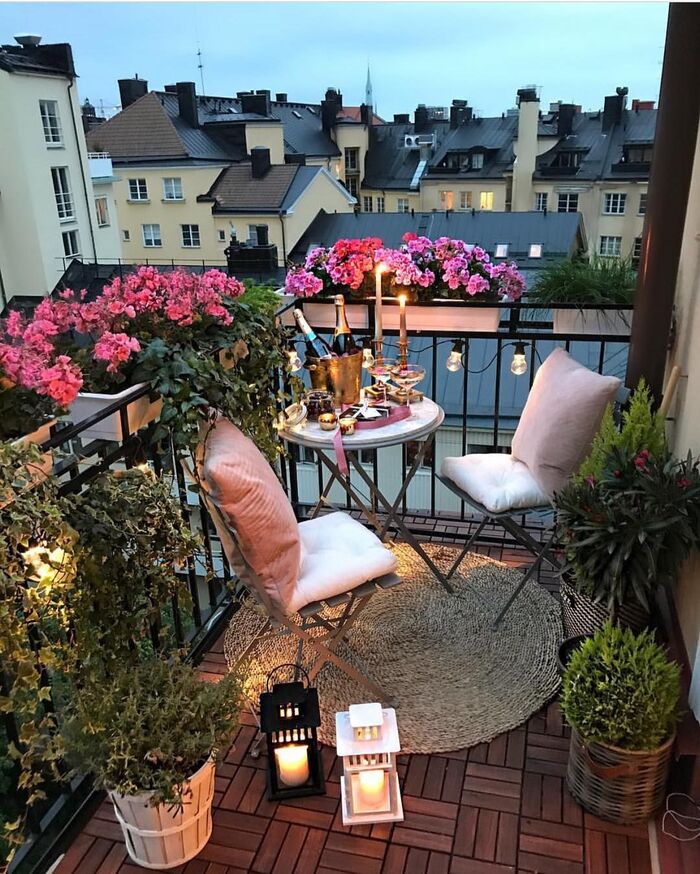 cute small balcony with elegant decor small lanterns plants and a table with two chairs