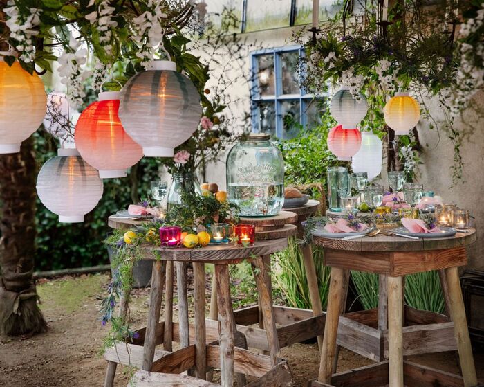 garden party ideas tall wooden tables colorful lanterns and flowers decorating an outdoor space