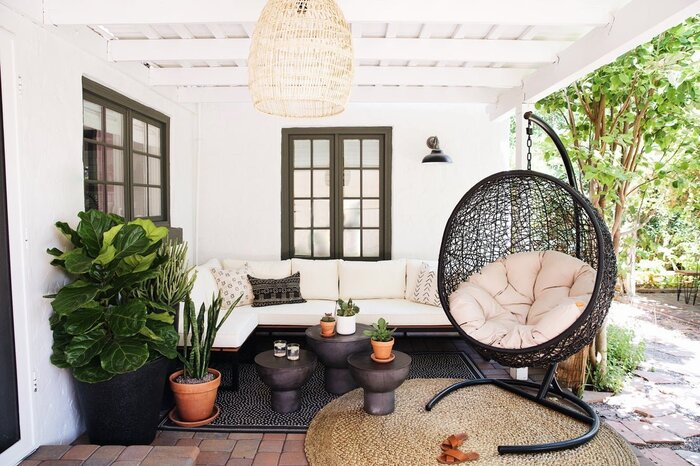 granada egg chair in black in a white backyard patio with living plants and white and black furniture