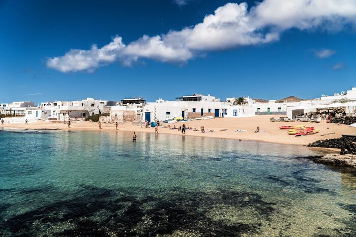 la graciosa spain island landscape with clear water and white houses in the background