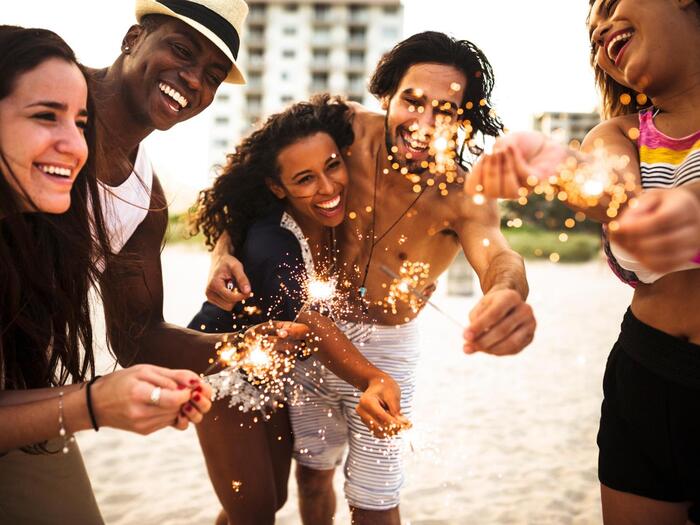 miami beach florida people on the beach in summer clothes smiling and holding sparklers