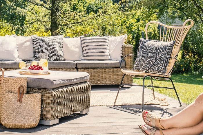 outdoor space with natural furniture in neutral colors woman relaxing with her legs in the picture