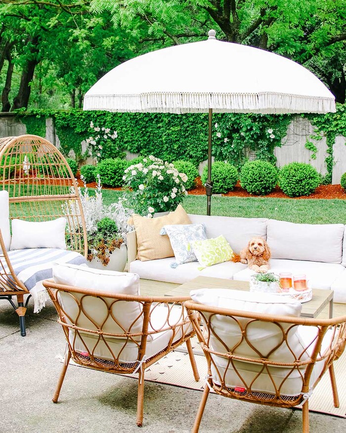 outdoor decor beautiful outdoor space with a white parasol rattan furniture and a dog sitting on the couch