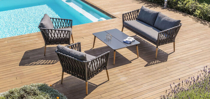 poolside with wooden floor with elegant black furniture a table and three chairs