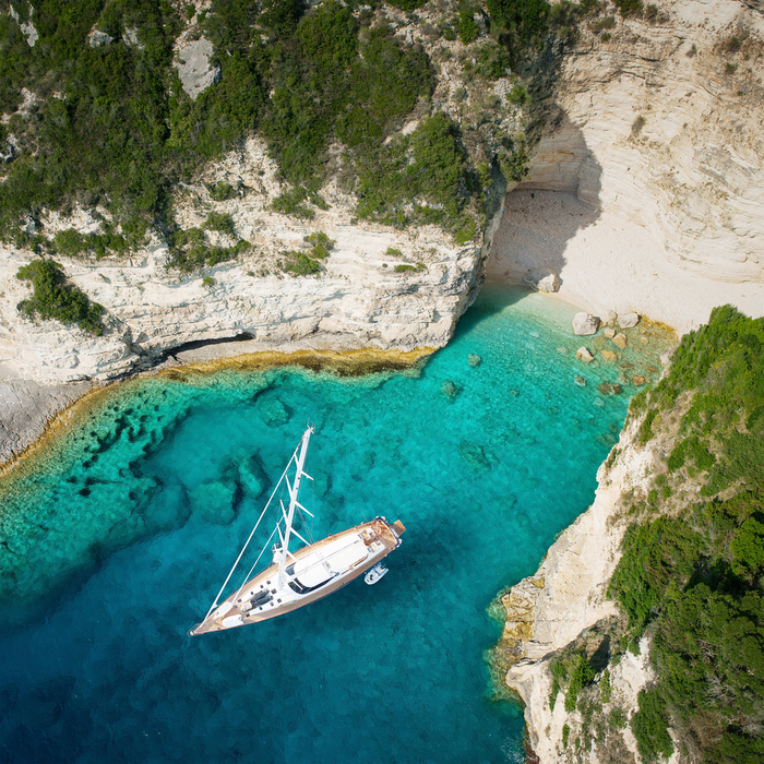 luxury sailing yacht in a bay in Greece with a virgin beach and clear blue water