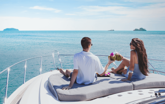 couple enjoying coconuts on a yacht with a beautiful view of the sea