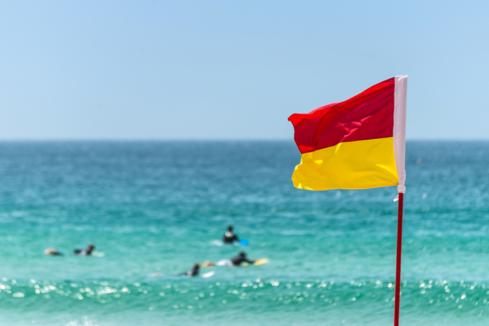 beach flags safety flag red and yellow with the blue sea in the background