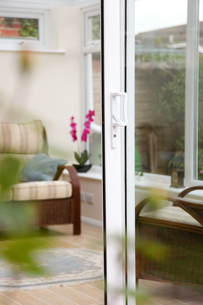 open white glass door with a living area inside and a garden outside