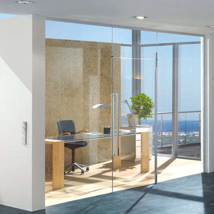 glass office space with large glass doors and windows and modern furniture