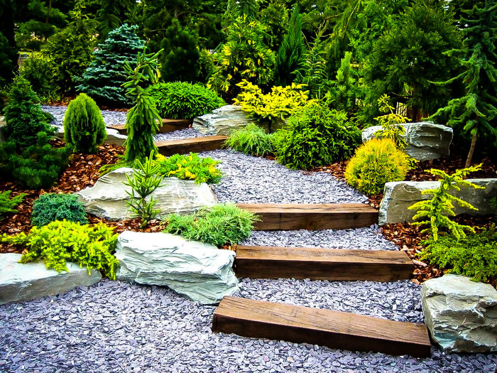 landscape design in a japanese style backyard wooden stairs and stones and green plants
