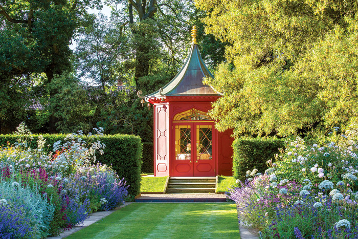 romantic english garden with a red pavilion and beautiful blossoming flowers 