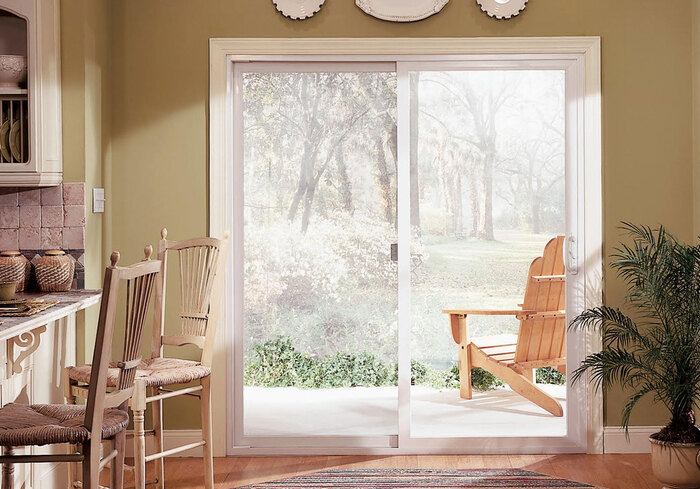 sliding patio door to a garden with trees in an elegant kitchen and dining space