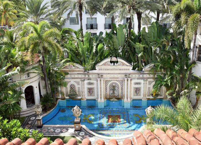 luxurious versace villa with palm and banana trees and a designer pool