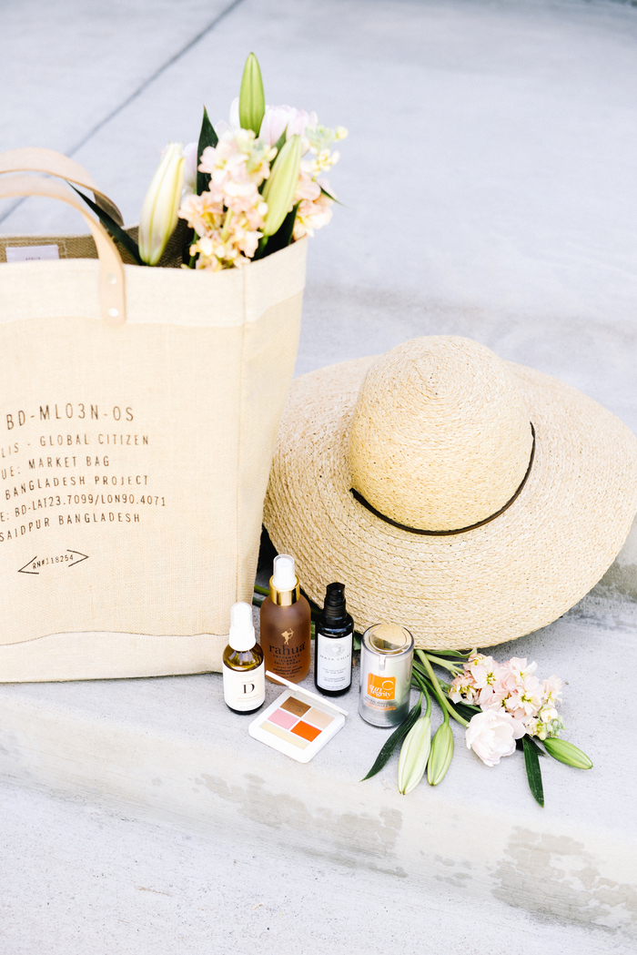 beauty kit summer products arranged in a beautiful way with a straw hat and a bag decorated with flowers
