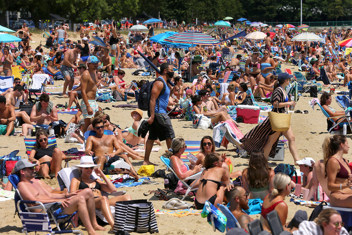crowded beach in summer with many people in swim suits enjoying their vacation