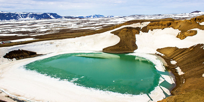 lake myvatn covered in ice with hills and rocks all around