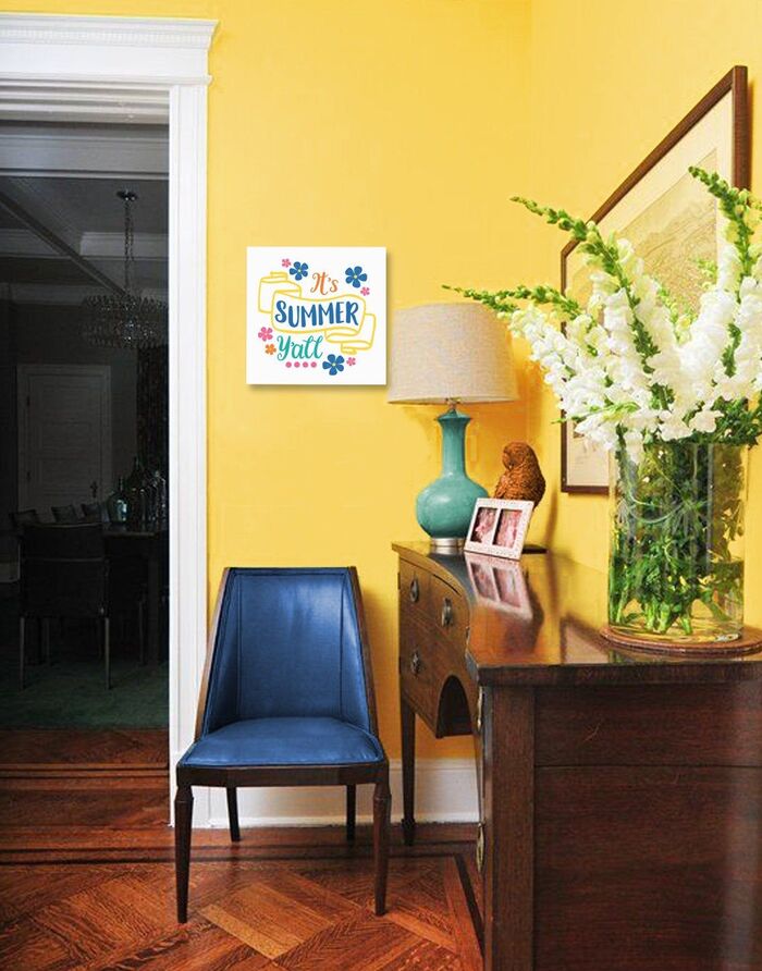 yellow shades in the interior summer color palette a corner of a living space painted in bright yellow with a vase with white flowers and a dark blue chair