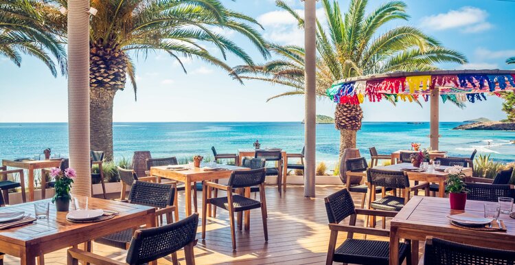 Ibiza Restaurant and beach bar with tall palm trees and colorful parasol