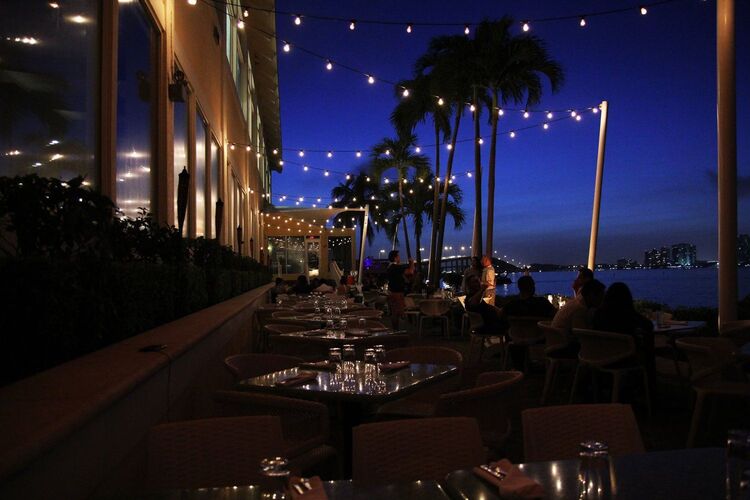 Rusty Pelican restaurant in the evening with outside lights and palm trees