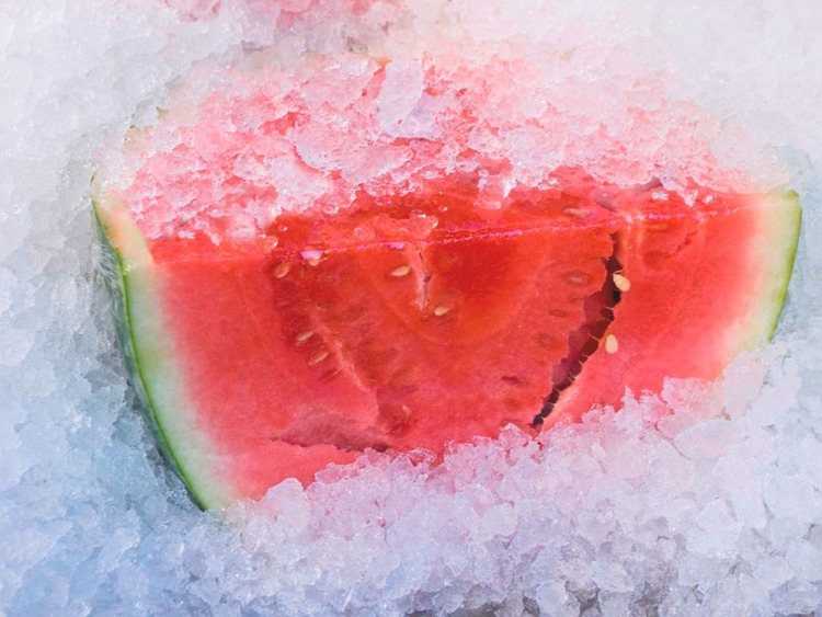 large piece of red watermelon surrounded by crushed ice
