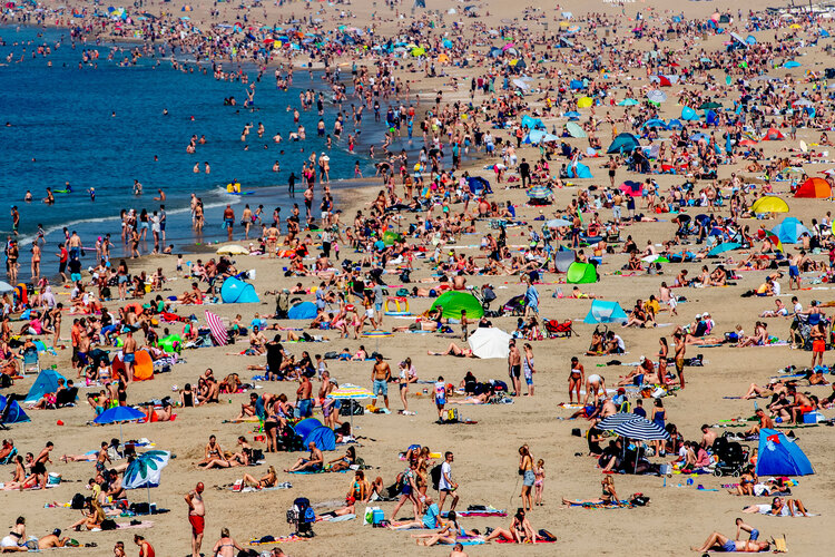 beach in the Netherlands crowded with people and colorful accessories