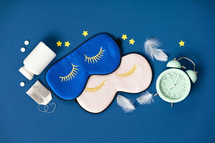 sleep schedule clock pills and sleep masks on a blue background