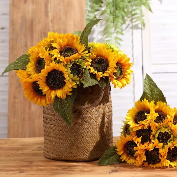 sunflower flower arrangements on a basket on a wooden surface