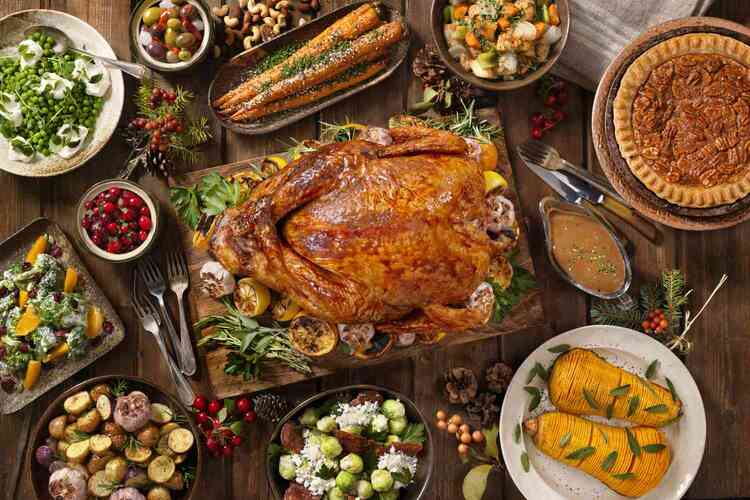 thanksgiving dinner table with various dishes and a large turkey in the middle